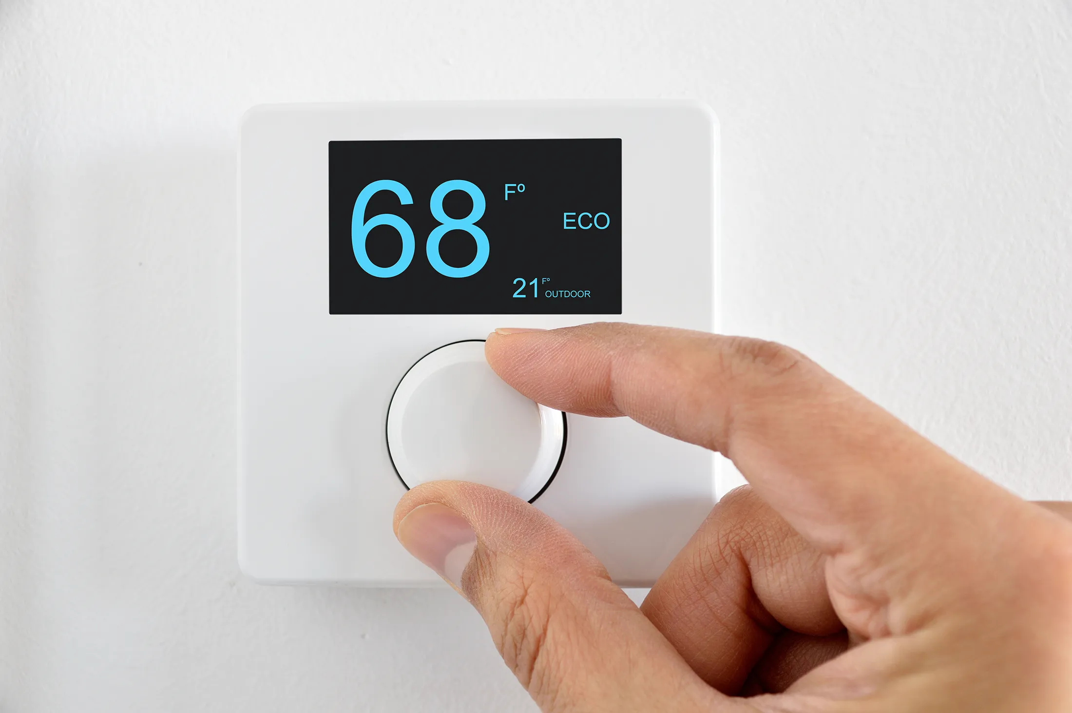 Hand on thermostat